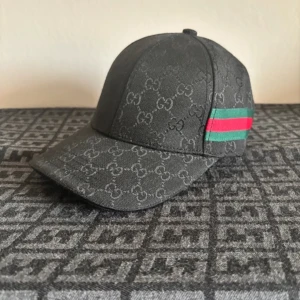 Helt ny G keps - Snygg svart G keps. Kepsen har en justerbar rem baktill och detaljer i rött och grönt på sidan. Perfekt för sommaren. Priset går att diskutera vid snabb affär