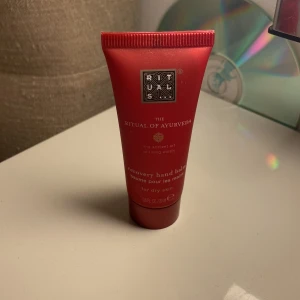 Rituals The Ritual of Ayurveda hand balm - En lyxig röd tub med hand balm från Rituals, The Ritual of Ayurveda-serien. Perfekt för torr hud och har en mjukgörande formula. Tuben rymmer 20 ml och är smidig att ha med i väskan.