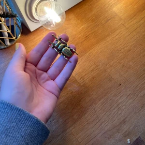 Stor guldfärgad skalbaggering - Cool statementring i form av en skalbagge i guldfärgad metall. Ringen är stor och täcker nästan hela två fingrar, perfekt för dig som vill sticka ut och addera en edgy touch till din stil. PRIS KAN EISKUERAS POSTAR SNABBT