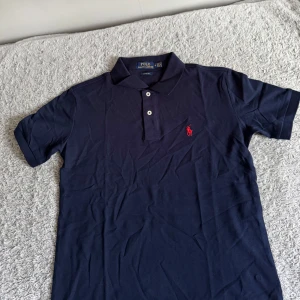 Marinblå pikétröja från Polo Ralph Lauren - Snygg marinblå pikétröja från Polo Ralph Lauren i storlek M. Helt ny aldrig använd!