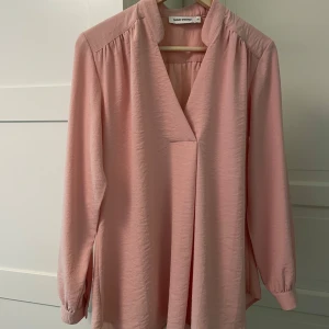 Rosa blus från Carin Wester - En något längre och rymligare rosa blus från Carin Wester i storlek 36. Materialet är en blandning av viskos, polyester och polyamid.