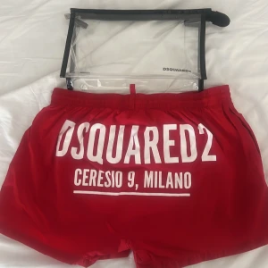 Röda badshorts Dsquared2 - Röda Dsquared2 bad shorts autentiskt storlek M bra skick produkten tillverkas inte längre.