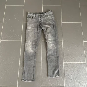 Jack&jones jeans  - Snygga grå jeans med skinny fit och lätt slitna detaljer. Klassisk femficksmodell med dragkedjegylf och smala ben. Perfekta för dig som gillar en tajt look och streetkänsla. Passar till allt och är riktigt bekväma.