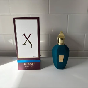 Xerjoff Erba Pura Eau de Parfum 100ml - Lyxig parfym från Xerjoff, Erba Pura, i en elegant blågrön sammetsflaska med guldfärgat lock och detaljer. Flaskan rymmer 100 ml och har en unik, sexkantig botten. Kommer med originalkartong i vitt, vinrött och blått med guldtext. Kvitto kan även rotas fram! Unisex men mer åt den herrliga sidan. 96/100 ml