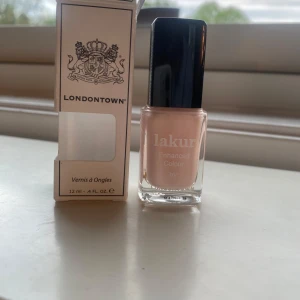Londontown Lakur nagellack Invisible Crown - Ljusrosa nagellack från Londontown i nyansen Invisible Crown. Kommer i en stilren glasflaska med svart lock och rymmer 12 ml. Ger en mjuk, naturlig finish och passar perfekt för en fräsch look. Enkel att applicera med klassisk borste. Nypris 200 helt oöppnad 