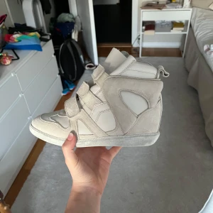 Isabel marant skor  - Kan tänka mig sänka pris. Ljus beiga Isabel marant sneakers i modellen buckee. De har kilklackar o storleken är 37. Sååå snygga men tyvärr kommer inte till användning (har bara används 2 ggr). ❤️🥰 Kommer med original kartong o dustbag! Bara skriv om några funderingar.