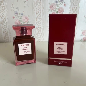 Tom Ford Lost Cherry EdP 100ml - Tom Ford Lost Cherry Eau de Parfum 100 ml med lyxig, fyrkantig glasflaska i mörkröd och rosa nyans. Kommer med matchande röd kartong. Doften är känd för sina söta körsbärstoner och exklusiva känsla. Perfekt för dig som vill sticka ut med en unik och djärv parfym.