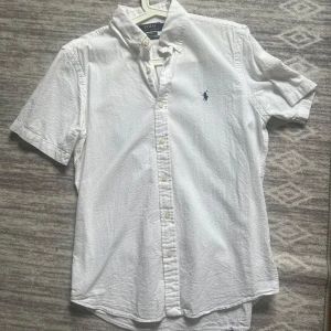 Ralph lauren kortärmad skjorta - Väldigt bra skick , inga skador eller  fläckar ! Köpt på Ralph laurens hemsida. Jag är 177 och passar bra!