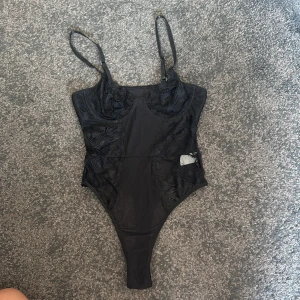 Svart spetsig korsettbody - Säljer denna snygga svarta spetsig body!! Aldrig använd