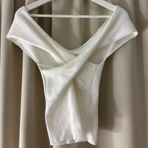 omlott offshoulder topp - Supersnygg vit ribbad topp med omlott och offshoulder-design. Sitter så fint på! Om fler bilder önskas eller vid frågor kontakta mig💋