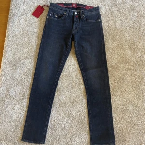Tramarossa Leonardo Buttons W30 - Svarta jeans med mörkröda detaljer från tramarossa. Modellen heter Leonardo buttons, storlek W30. Aldrig använda, ny pris över 3500kr. Säljer för att jag glömde lämna tillbaka dem. Bokstäverna (initialerna) går att ta bort eller byta ut till andra bokstäver. Skriv för mer information eller fler bilder. 
