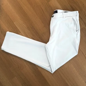 Vita kostymbyxor med raka ben - 100% stretch. Storlek 32 (motsvarar Medium). Slim fit och väldigt stilrena. Märket är ett frågetecken då de köptes utomlands. 