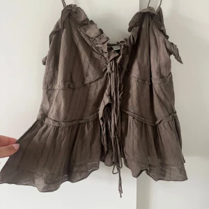 Söt topp - Supersöt brun topp från Zara med tunna axelband, volangdetaljer och snörning framtill. Perfekt för varma dagar och snygg att styla med jeans eller kjol!🩷 tryck gärna på köp nu så fraktar jag fort🌸