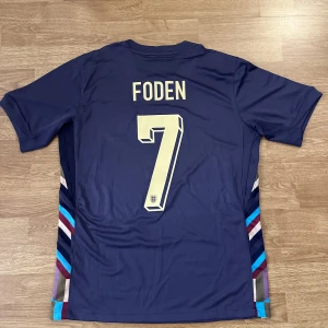 England Foden #7 fotbollströja - Englands bortaställ i marinblå färg med 7 Foden på ryggen. Storlek S