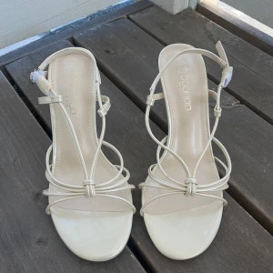 Klackar - Boohoo - Fina klackar som är perfekt till sommaren!😊 Helt nya, endast provade. Färgen är natutvit. liten buckla/defekt bak på vänster klack - syns på bild (fick dem så, skada från transporten). Smal klackar men stabila, ca. 9cm klack. 