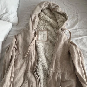 Beige hoodie med fluffig insida - Extremt mysig hoodie med dragkedja och huva. Insidan är fodrad med supermjukt, fluffigt material som är så sjukt mysigt. Den säljs inte längre, jag köpte den för 300!