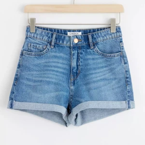 Blå jeansshorts - Snygga blå jeansshorts från Indiska med klassisk femficksdesign och uppvikta benslut. Perfekta för varma dagar och enkla att matcha med olika toppar. Normal passform och bälteshällor i midjan.