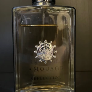 Amouage Reflection Eau de Parfum 100ml - Lyxig parfym från Amouage, Reflection Eau de Parfum i en elegant, genomskinlig glasflaska med silverdetaljer och logotyp framtill. Flaskan rymmer 100 ml och har en stilren, rektangulär form. Tillverkad i Oman och passar dig som gillar exklusiva dofter. 85 ml kvar, öppet för byte och prisförslag