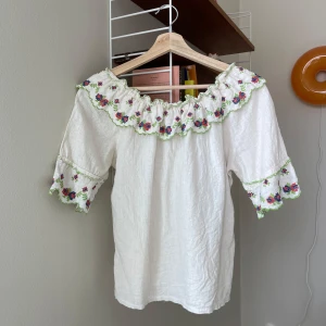 Vintage blus  - Vacker blus med volangkrage med broderi. Omärkt men uppskattar till strl S. Tyg i linne eller möjligenbomull. Fint skick!