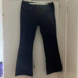 Svarta lowboot jeans - Snygga svarta jeans. Byxorna har en mörk färgton och utsvängda ben. Perfekta för dig som gillar en retroinspirerad look. Short length. De är svart men bilderna va inte så bra så du kan kontakta mig om du tänker på att köpa byxorna 