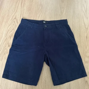 Chinoshorts - Säljer ett par mörkblå chinoshorts från lager 157. De är använda kanske en eller två gånger och skulle därför säga att de är i nyskick. 