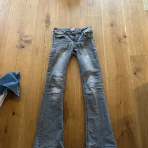 Grå bootcut jeans från D-XEL - Snygga grå jeans från D-XEL i bootcut-modell. Jeansen har klassisk femficksdesign, normal passform och är tillverkade i mjukt denimtyg. Perfekta för dig som gillar en retroinspirerad look med utsvängda ben.