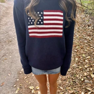 Mörkblå stickad tröja  - Mörkblå stickad tröja med en stor amerikansk flagga framtill. Tröjan har långärmad modell och ribbade muddar vid ärmslut och nederkant. Perfekt för dig som vill sticka ut med en cool och klassisk look.