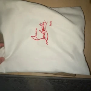 Christian Louboutin svarta sneakers med nitar - Svarta sneakers från Christian Louboutin med coola svarta nitar på tån. Skorna har snörning och är gjorda i mocka med läderdetaljer. Snygg och edgy design som sticker ut, levereras med original dustbag och låda.