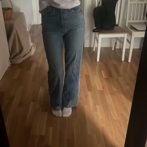 Högmidjade blå jeans med raka ben - Säljer ett par klassiska blå jeans med hög midja och raka ben. Jeansen har en snygg tvätt och sitter tajt över höfterna men är raka och lite vidare nertill. 
