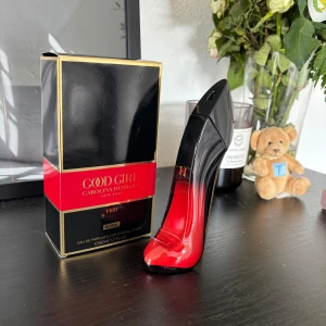 Good Girl Very Elixir parfym 50ml - Good Girl Very Elixir från Carolina Herrera i en ikonisk stilettklacksflaska med svart och röd glasdesign och gulddetaljer. Parfymen är 50ml och kommer i en lyxig svart och röd kartong med guldfärgade kanter. Perfekt för dig som gillar statement-flaskor.