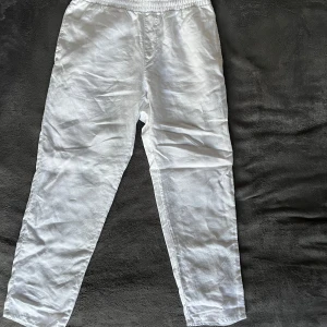 Vita linnebyxor från H&M - Säljer ett par fräscha vita linnebyxor från H&M i storlek M med elastisk midja och raka ben. Byxorna är lätta och luftiga, perfekta för varma dagar. De har en enkel och clean look som passar till det mesta. 