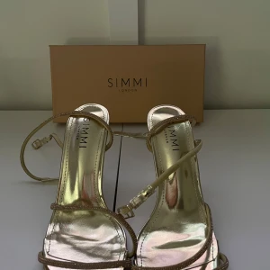 Guldiga klackskor från Simmi London - säljer mina guldiga klackskor, de är använda ett fåtal gånger!! klackhöjd: 9,5 cm💗 