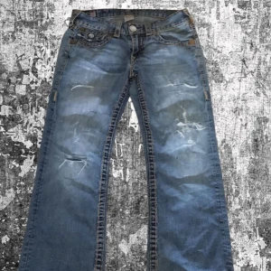 Bootcut True religion jeans vintage med!! - Waist 32 bootcut vintage rare to find för dom här är og colorway än dom andra nya! Men säljer för inte så mycket! Har heel bite bilder kan fixas om ni skriver frågar svarar snabbt!! Priss går att diskutera såklart!!! (OBS har lagat byxorna med lagg lappar på visa ställen)