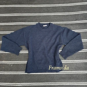 Mörkblå stickad tröja från Gina Tricot - Mysig mörkblå stickad tröja från Gina Tricot med rund halsringning och långa ärmar. Perfekt för kyligare dagar och enkel att matcha med olika outfits.