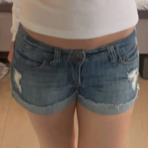 Blå jeansshorts med slitningar - Säljer ett par blå jeansshorts med slitna detaljer och låg midja. Skriv för frågor💞💞