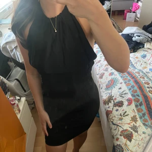 Svart halterneckklänning från Zara Basic - Säljer en svart kort halterneckklänning från Zara Basic. Klänningen är ärmlös med öppen rygg och har en tight passform som framhäver figuren. Storlek M men passar xs/s.