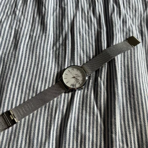 Marmor Klocka - Klocka från H&M med marmorerad bakgrund. 24cm lång, fästet är inställt på 20cm men den går att justera!