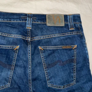 Nudie Jeans - Feta Nudie Jeans  — Grim Tim — Bra skick — Hög Kvalite 👍— Nypris 1600kr — Mitt pris endast 449kr 💸 — Mörkblå färg — Storlek W29 L32 — Lite slitet vid skrevet — Hör av er vid frågor🤔— Priset ej hugget i sten 🪨⛏️
