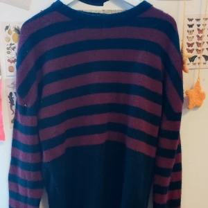 Randig stickad tröja i vinrött och svart - (Kan sy den croppad om du så vill till inget extra!!) Mysig stickad tröja med breda vinröda och svarta ränder. Tröjan har rund halsringning och långa ärmar. Perfekt för kyligare dagar och passar till både jeans och kjol.