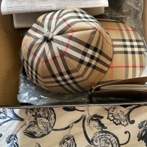 Burberry keps - Använd några gånger, kvitto finns, Den är i mkt bra skick. Tveka inte på att höra av dej om du har någon fråga :)