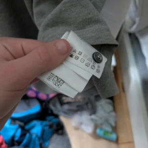 Grå piké från Moncler - Säljer en stilren grå pikétröja från Moncler med klassisk krage och knappslå. Tröjan har Moncler-logga på bröstet och är tillverkad i mjuk bomull. Perfekt för en clean och avslappnad look.