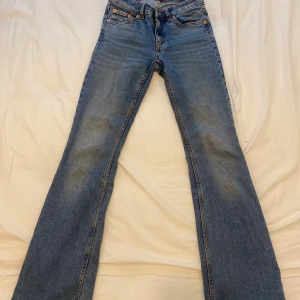 Blå bootcut jeans från 157 - Säljer ett par klassiska blå bootcut jeans från 157 med normal passform. Jeansen har fem fickor, dragkedja och knapp framtill samt snygga kontrastsömmar. Perfekta för dig som gillar en tidlös denimlook.