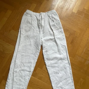 Vita linnebyxor från Zara - Säljer ett par vita linnebyxor från Zara i storlek XL. Byxorna har resår i midjan och raka ben, vilket gör dem både bekväma och stilrena. Perfekta för varma dagar och enkla att matcha med olika toppar.