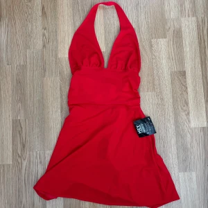 Röd halterneckklänning Nelly - Säljer en snygg röd halterneckklänning från Nelly med djup v-ringning och knyt i ryggen. Klänningen har en kort längd och markerad midja. Supersnygg färg och feminin passform! Aldrig använd. Prislapp kvar❤️ Storlek S. Pris 50kr