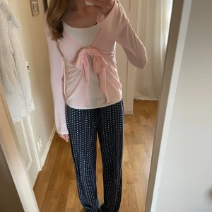 Ljusrosa knyttopp, Gina tricot  - Säljer en söt ljusrosa omlottkofta med lång ärm och stor rosett framtill. Koftan är tunn och  perfekt att ha över ett linne eller topp. Den är från Gina tricot och är i storlek xs❣️ Den är i nyskick och aldrig använd.