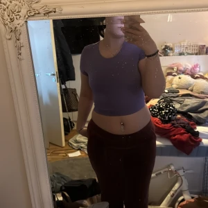 Lila croppad omlottopp från SHEIN - Säljer en lila croppad topp från SHEIN i omlottmodell med knyt i ryggen. T-shirtrund hals och korta ärmar. Perfekt för dig som gillar trendiga och färgglada plagg!