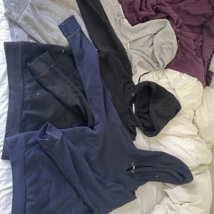 Tre hoodies i olika färger - Säljer tre stilrena hoodies i färgerna marinblå, svart och ljusgrå. Alla har huva med dragsko och klassisk passform. Perfekta för en avslappnad look och funkar året runt.