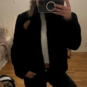 Svart teddyjacka med krage - En vit fin päls väst. Köpt på Sellpy och är ej använd av mig. Prislappen är kvar. Märket är Kardashians bebe!💞