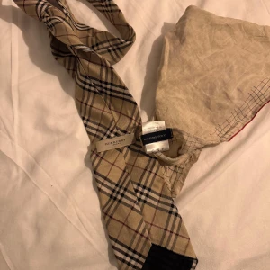 Burberry Slips och näsduk  - Äkta slips och näsduk för dig som vill lyfta upp looken lite på någon fest, bröllop eller något annat kul?. Använda 1 gång.