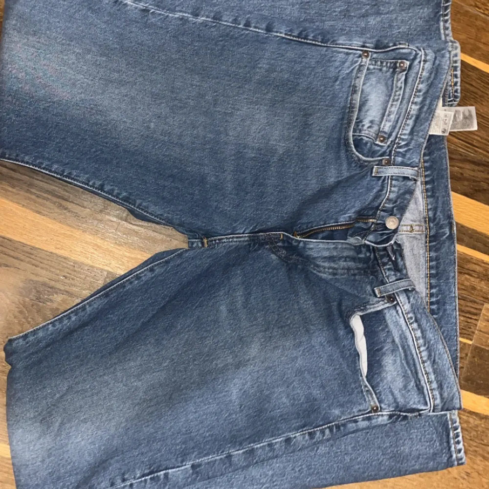 Klassiska blå Levis 502 jeans med raka ben och femficksdesign. Byxorna har normal passform och är tillverkade i slitstarkt denim med knappgylf. Perfekta för dig som gillar tidlös stil och kvalitet.. Farkut & Housut.